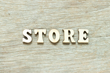Alphabet letter in word store on wood background
