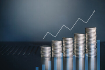Stack of money coin on office desk with growth arrow. Business and financial concept. 
