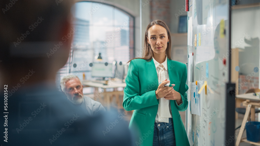 Poster Female Project Manager Makes a Presentation for a Diverse Creative Team in Meeting Room in an Agency. Colleagues Gathering Around Conference Table and Discuss Business Development and Design.