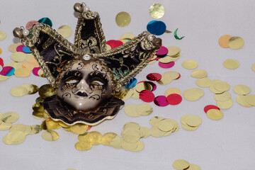Máscara veneciana sobre un fondo blanco con temática de Carnavales con confeti de colores por...