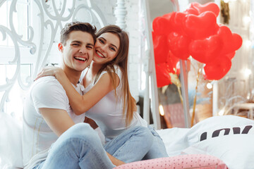 Beautiful young couple at home. Hugging, kissing and enjoying spending time together while...