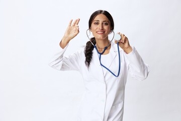 Woman doctor with stethoscope in hand in medical gown on white nurse background, consequences of covid-19, noise in lungs, concept of health and science