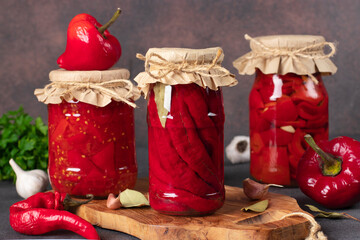 Various types of pickled peppers - chili peppers, sweet peppers with garlic and peppers in tomato...