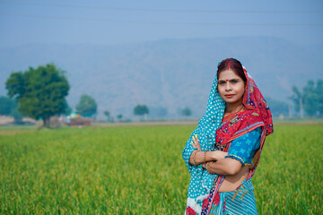 Indian rural woman standing at agriculture field.