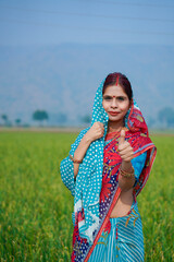 Indian rural woman showing thumps up at agriculture field