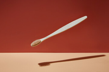 Wooden biodegradable bamboo toothbrush drops on a colored background. Health, environment and zero...