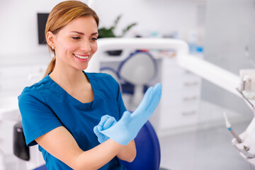 Female doctor putting medical protective gloves on