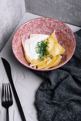 Dumplings with cottage cheese with sour cream on a plate