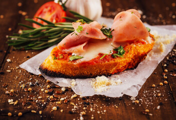 Toassted baguette slices with prosciutto cotto and cream cheese