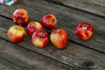 Ripe red apples on wooden background .