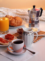 Continental breakfast with fresh croissants, buns with jam, orange juice and coffee.