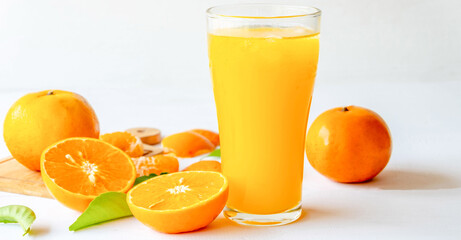 Freshly squeezed orange juice and orange fruit cut in half
