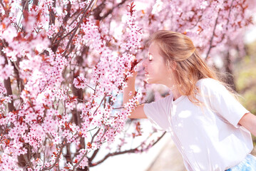 Portrait of a fashionable little girl near flowering trees