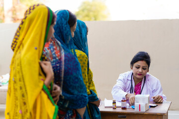 Young indian woman doctor advise to rural women at clinic