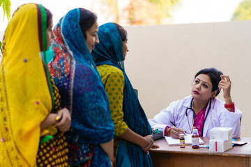 Young indian woman doctor advise to rural women at clinic