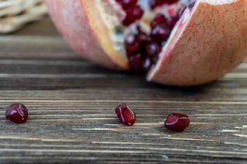 Pomegranates in a basket and on the table on a wooden background.