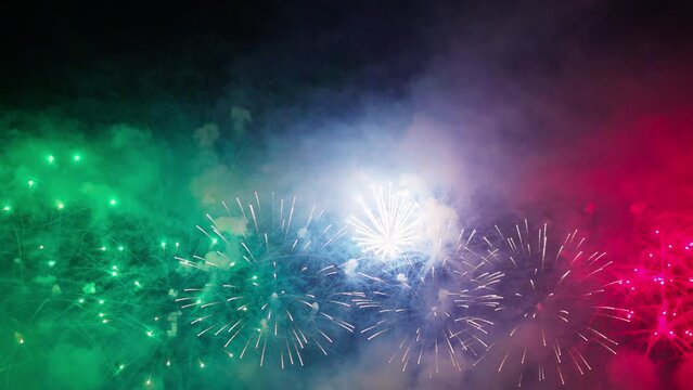 Colorful fireworks festival. Beautiful red fireworks close-up view in slow motion. Wonderful real fireworks in the night sky shot with a telephoto lens. fireworks show. 4K slow motion video.