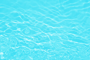 Defocus blurred transparent blue colored clear calm water surface texture with splashes and bubbles. Trendy abstract nature background. Water waves in sunlight with caustics. Blue water shinning 