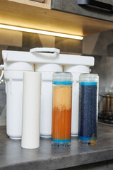 Replaceable cartridges in the water filter system. Water filtration system with replaceable cartridges. A system in the apartment with three tanks for cleaning tap water.