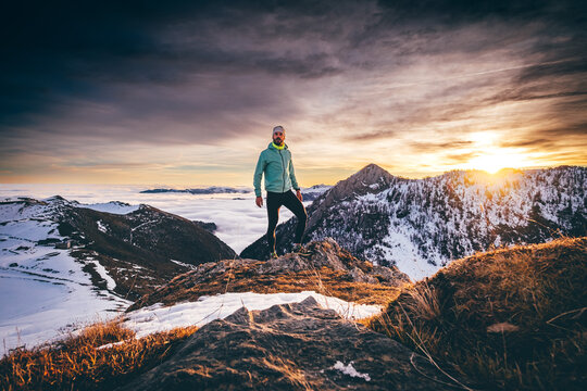 Man trail running in winter on a snowy mountain