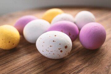 Obraz na płótnie Canvas Colorful chocolate Easter eggs on wooden background with copy space