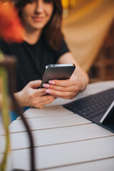 Happy Woman freelancer talking phone and using laptop on cozy glamping tent in a sunny day. Luxury camping tent for outdoor summer holiday and vacation. Lifestyle concept