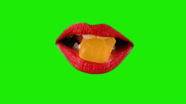 Female Mouth Gummy Bear Bite Tease Red Lipstick Green Screen Background. Mouth of a woman wearing red lipstick with a gummy bear candy on a green screen background