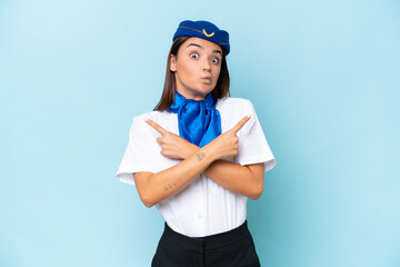Airplane stewardess caucasian woman isolated on blue background pointing to the laterals having doubts