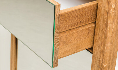 Drawer with mirror side close view photo, wooden eco furniture elements background. Solid wood furniture details