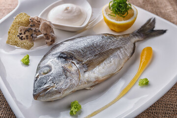 Baked dorado fish with sauce and lemon