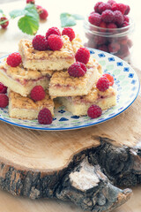 Raspberry pie cut into stacked pieces and garnished with raspberry berries