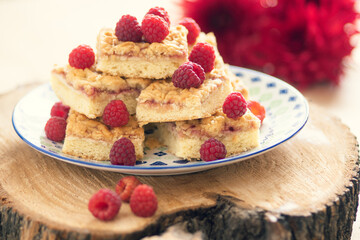 Raspberry pie cut into stacked pieces and garnished with raspberry berries