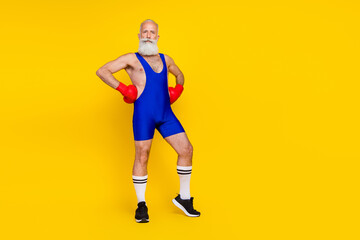 Fototapeta na wymiar Full length photo of serious confident retired man dressed blue overall costume practicing boxing empty space isolated yellow color background
