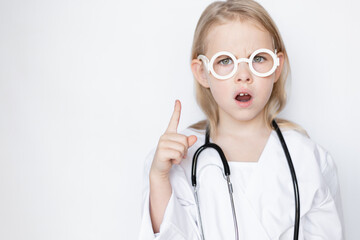 Angry, serious little girl dressed up in doctor attire with toy glasses and stethoscope, copy space