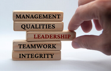 Management, qualities, leadership, teamwork and integrity text on wooden blocks with white background. Leadership concept