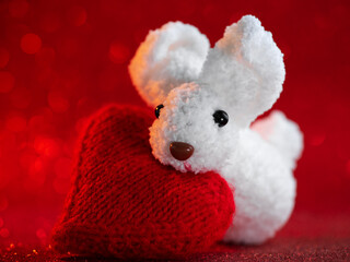 Happy Valentine's day greeting card with a white rabbit and a heart on a red background