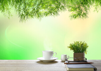 Green leaves of bamboo It is on top and the bokeh is visible.
On the table there is a cup of coffee and glasses, diary, books, pens and notebooks on the wooden floor.