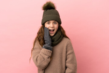 Little girl with winter hat isolated on pink background with surprise and shocked facial expression