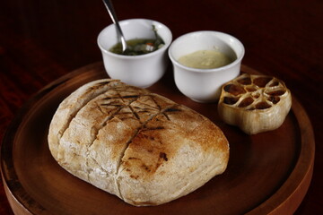 Rustic baked bread with condiments and head of garlic