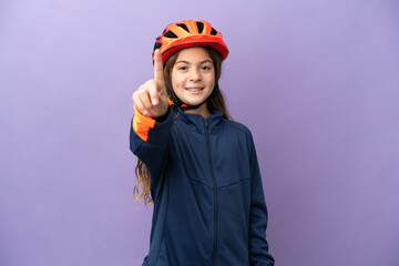 Little caucasian girl isolated on purple background showing and lifting a finger