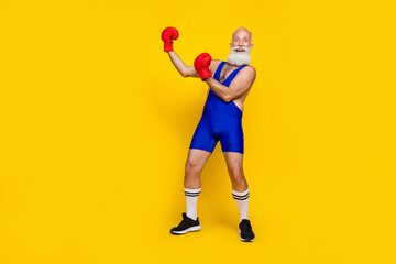 Side profile photo of grandfather wear blue costume wear red gloves kickboxing stadium positive versus empty space isolated on yellow color background