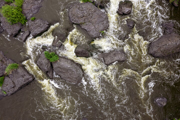 aerial view from above on a mountain river with stones and water
