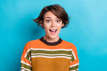 Portrait of impressed positive cheerful woman with short hairdo wear orange sweater staring open mouth isolated on blue color background