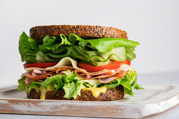 High Closed Sandwich with wholemeal bread, cheese, ham, tomatoes, cucumber and letuce salad leaves