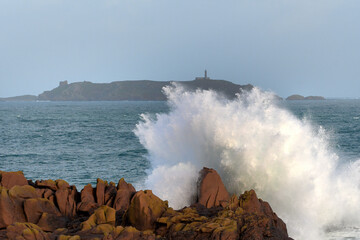 Fototapeta na wymiar Une grosse vague qui s'écrase sur un rocher en Bretagne