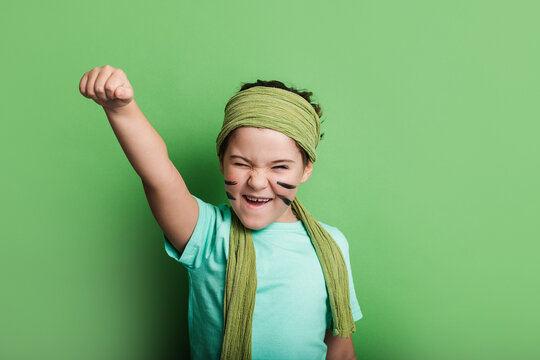 Excited girl clenching fist and screaming on green background