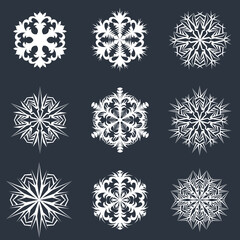 Lace pattern of white snowflakes on a dark gray background. A unique author's snowflake to decorate the winter holidays. Vector image of a Christmas symbol.
