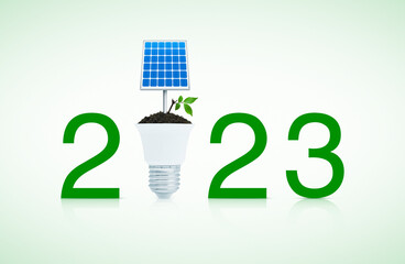 2023 text with solar cell and fresh green tree leaves on soil with led light bulb on white background, Happy new year 2023 green ecology and saving energy concept