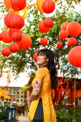 Beautiful Vietnamese woman in traditional vietnamese dress near red lanterns in Tet  Lunar New Year