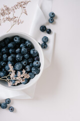 Blueberry berries in bowl on beide background